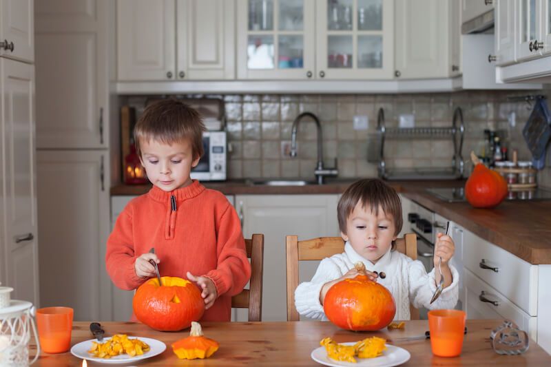 Two Little Boys Carving Pumpkins