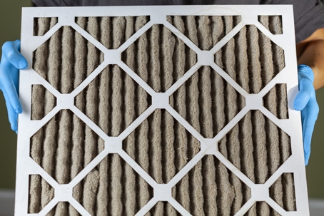 man holding dirty air filter