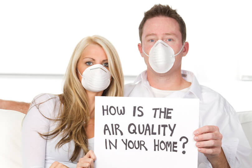 Couple wearing mask holding sign