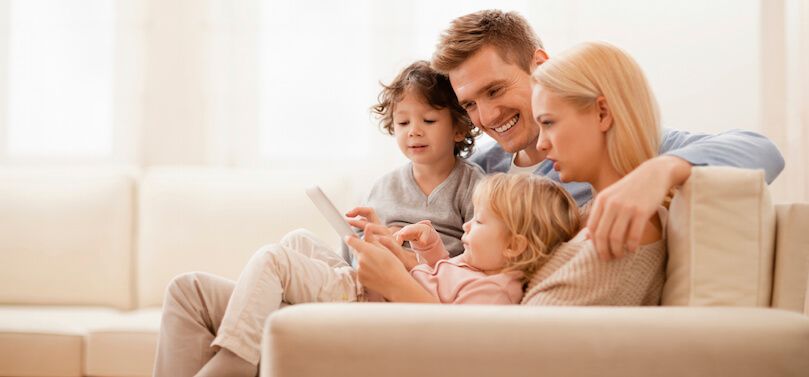 Family on couch enjoying AC