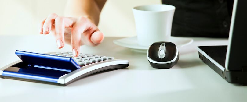 Woman typing on calculator 