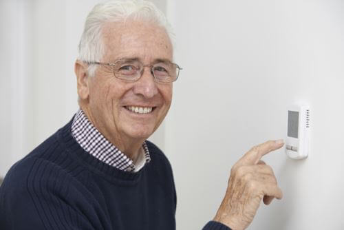 Man adjusting thermostat